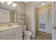 Bathroom featuring a vanity, wood look floors, shelving, toilet and view of a yellow hallway at 2508 Grassy Point Dr # 106, Lake Mary, FL 32746