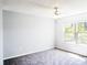 Bright bedroom featuring neutral walls, grey carpet, a ceiling fan and a sunny window at 2508 Grassy Point Dr # 106, Lake Mary, FL 32746