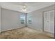 Neutral bedroom featuring two sunny windows, carpeted floors, ceiling fan, and a closet at 2508 Grassy Point Dr # 106, Lake Mary, FL 32746