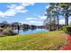 Picturesque lake view featuring a large lake, green grass and trees under a sunny sky at 2508 Grassy Point Dr # 106, Lake Mary, FL 32746