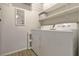 Clean laundry room featuring a washer, dryer, white walls and shelving at 2508 Grassy Point Dr # 106, Lake Mary, FL 32746