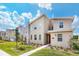 Modern two-story home featuring stone accents, a well-manicured lawn, and a vibrant blue sky at 2839 Bookmark Dr, Kissimmee, FL 34746