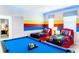 Fun game room featuring a pool table and twin beds with colorful superhero-themed decor and striped accent wall at 2839 Bookmark Dr, Kissimmee, FL 34746