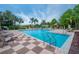 Beautiful pool area with ample lounge chairs, palm trees, and clear blue water, ideal for leisure and recreation at 3021 Red Ginger Rd, Kissimmee, FL 34747