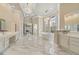 Elegant primary bathroom featuring marble floors, chandeliers, dual vanities, and a free-standing tub at 3037 Seigneury Dr, Windermere, FL 34786