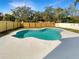 A beautiful swimming pool surrounded by a well-maintained concrete deck and a wooden fence at 3230 Buck Hill Pl, Orlando, FL 32817