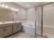 Serene bathroom with double vanity, soaking tub, and glass-enclosed shower with tiled walls at 367 Sofia Ln, Lake Alfred, FL 33850