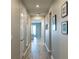 Well-lit hallway with wood-look flooring and stylish wall decor leading to a cozy living space at 367 Sofia Ln, Lake Alfred, FL 33850