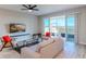 Bright living room with stylish furniture, ceiling fan, and sliding glass doors to an outdoor patio at 367 Sofia Ln, Lake Alfred, FL 33850