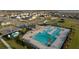 Aerial view of a resort-style community pool with palm trees, lounge chairs, and a shaded pavilion at 367 Sofia Ln, Lake Alfred, FL 33850