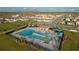 Aerial view of a community pool with sunshades, palm trees, and lounge chairs in a well-kept neighborhood at 367 Sofia Ln, Lake Alfred, FL 33850