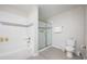 Bright bathroom featuring a shower with a glass door, a white tiled bathtub, and white fixtures at 4000 Breakview Dr # C207, Orlando, FL 32819