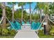 Outdoor fire pit surrounded by Adirondack chairs, set amidst a beautifully landscaped area with palm trees at 4000 Breakview Dr # C207, Orlando, FL 32819