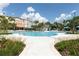 Beautiful swimming pool surrounded by palm trees, blue umbrellas, and lush landscaping at 4000 Breakview Dr # C207, Orlando, FL 32819