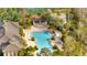 Aerial view of a resort-style community pool with a waterfall feature, hot tub, and sun loungers at 4019 Alcott Cir, Orlando, FL 32828