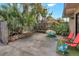 Private backyard featuring a concrete patio, tropical plants, and colorful chairs at 5293 Willow Ct # 522, Orlando, FL 32811