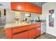 Updated kitchen featuring orange cabinetry, stainless steel sink, and butcher block countertops at 5293 Willow Ct # 522, Orlando, FL 32811