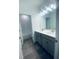 Bathroom featuring a double sink vanity with modern fixtures and a walk-in shower at 5960 Vision Rd, St Cloud, FL 34771