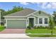 Charming single-story home featuring a brick driveway, green grass, and a cozy entrance at 5960 Vision Rd, St Cloud, FL 34771