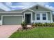 Inviting home featuring a brick driveway, manicured lawn, and tasteful landscaping at 5960 Vision Rd, St Cloud, FL 34771