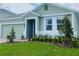 Landscaped front yard with lush green lawn, colorful flowers, and a charming entry at 5960 Vision Rd, St Cloud, FL 34771