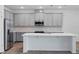 Modern kitchen boasts stainless steel appliances, ample gray cabinets, and a large central island at 5960 Vision Rd, St Cloud, FL 34771