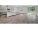 Open-concept living area features tile flooring, a kitchen island, and glass sliding door to the outside at 5960 Vision Rd, St Cloud, FL 34771