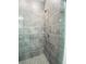 A bathroom shower features a gray tiled wall and flooring, and sleek fixtures at 5960 Vision Rd, St Cloud, FL 34771
