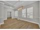 Open dining room featuring wood floors, gray walls, trey ceiling, and a modern pendant light fixture at 610 Nadina Pl, Celebration, FL 34747