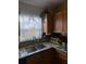 Kitchen sink area with a granite countertop, wooden cabinets, and bright natural light at 680 Caribou Ct, Apopka, FL 32703