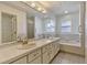 Bathroom featuring double sinks, tile countertop, and a separate tub and shower at 700 Roby Ct, Dundee, FL 33838