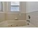 A close-up view of the bathroom tub with jets and a nearby window at 700 Roby Ct, Dundee, FL 33838