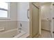 Bathroom featuring a tub with window and a separate glass door shower at 700 Roby Ct, Dundee, FL 33838