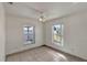 Bright bedroom with tile floors, ceiling fan, and two windows offering views of the outdoors at 700 Roby Ct, Dundee, FL 33838