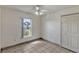 Bedroom features neutral walls, tile floor, ceiling fan, and a window for natural light at 700 Roby Ct, Dundee, FL 33838