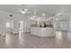 Open concept living area with tile flooring, ceiling fan, and a breakfast bar connecting to the kitchen at 700 Roby Ct, Dundee, FL 33838