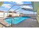 View of a screened-in swimming pool, deck, and patio surrounded by a fenced-in yard at 700 Roby Ct, Dundee, FL 33838