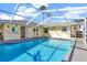 Outdoor view of an enclosed swimming pool with patio, pool-side decor, and a yellow house at 700 Roby Ct, Dundee, FL 33838