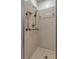 Accessible tiled shower with grab bars and hand-held shower head at 700 Roby Ct, Dundee, FL 33838