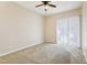 Bright bedroom featuring neutral carpeting, a ceiling fan, and a large window at 7624 Bay Port Rd # 40, Orlando, FL 32819