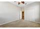 Neutral carpeted bedroom features a ceiling fan and a walk-in closet with a bathroom at 7624 Bay Port Rd # 40, Orlando, FL 32819