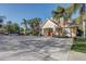 Exterior view of the clubhouse featuring tropical landscaping and dedicated parking spaces with accessibility options at 7624 Bay Port Rd # 40, Orlando, FL 32819