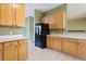 Bright kitchen showcasing ample wood cabinetry, black refrigerator and neutral countertops at 7624 Bay Port Rd # 40, Orlando, FL 32819