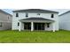 Home exterior featuring a covered patio and a lush green lawn in the backyard at 780 Pointe Emerson Blvd, Apopka, FL 32703