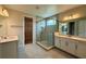 Bathroom with dual sinks, gray cabinets, a glass shower, and neutral toned walls at 780 Pointe Emerson Blvd, Apopka, FL 32703
