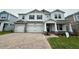 Charming two-story home with stone accents, a three-car garage, and a welcoming front porch at 780 Pointe Emerson Blvd, Apopka, FL 32703