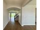 Hallway with arched entryway, staircase, wood-look tile flooring, and a view into the living room at 780 Pointe Emerson Blvd, Apopka, FL 32703