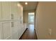 Hallway features wood-look tile floors and wall of built-in cabinets with countertop at 780 Pointe Emerson Blvd, Apopka, FL 32703