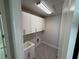 Functional laundry room featuring a sink and white cabinets for storage at 780 Pointe Emerson Blvd, Apopka, FL 32703