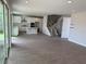 A modern living room with tile floors flows into the kitchen and stairway at 780 Pointe Emerson Blvd, Apopka, FL 32703